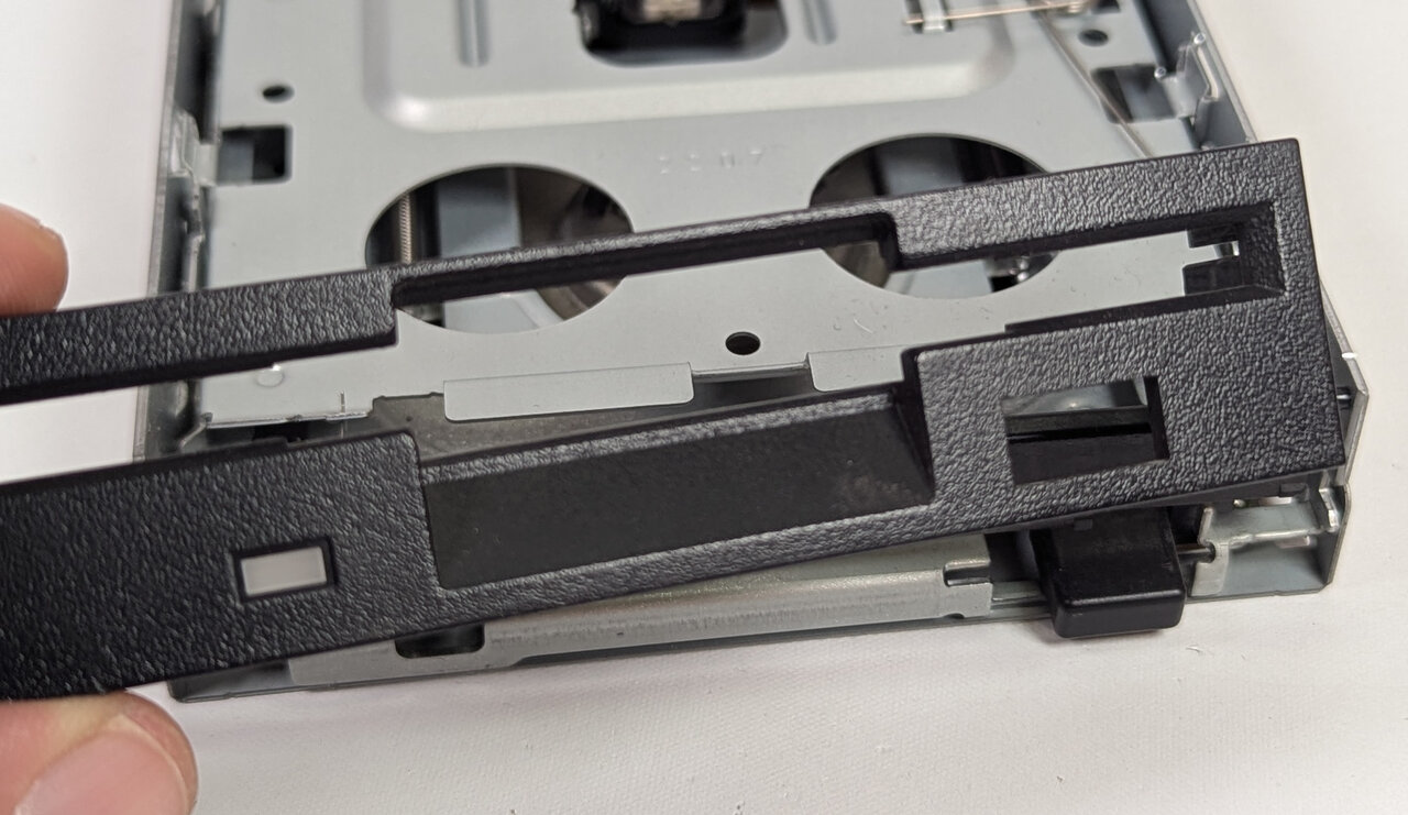 Bezel removed, flap staying with the drive