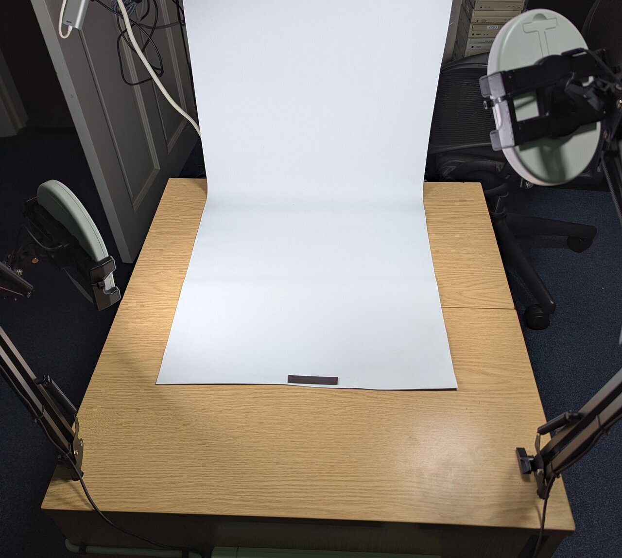 Two SAD lamps on mobile phone arms around a photo backdrop