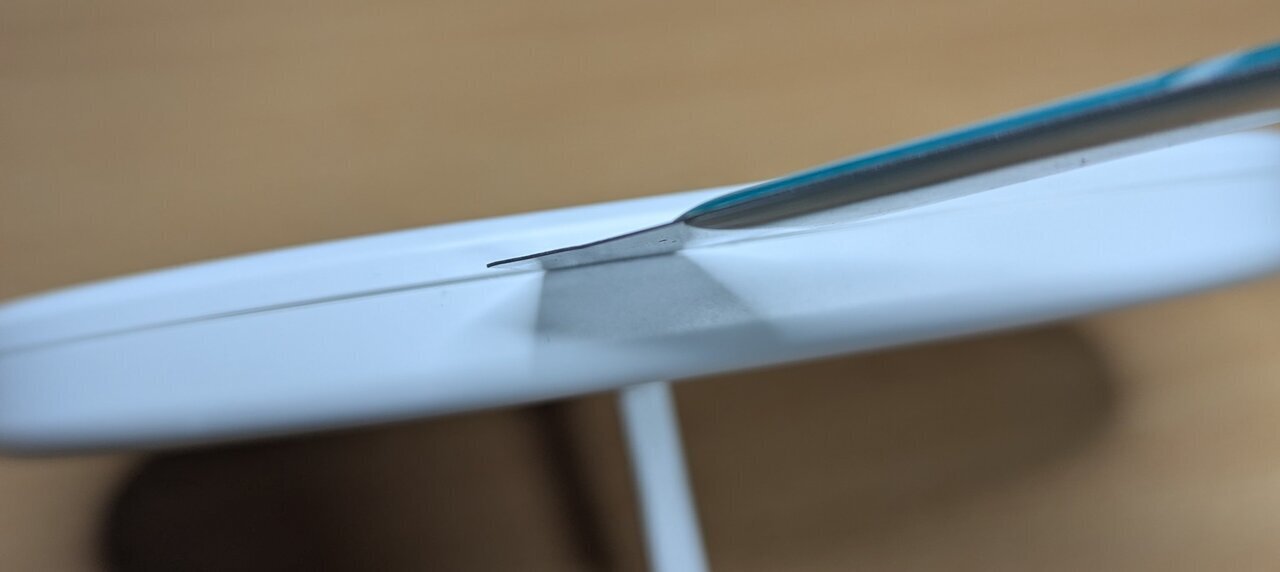 Spudger being used to open the lamp